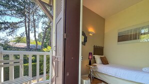 A bedroom with a bed, a bedside table, a lamp, and a window. - Pichilemu - Private Beach - Trouville-sur-Mer (Trouville-sur-Mer)