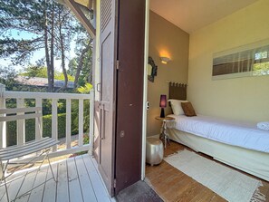 A bedroom with a bed, a bedside table, a lamp, and a window. - Pichilemu - Private Beach - Trouville-sur-Mer (Trouville-sur-Mer)