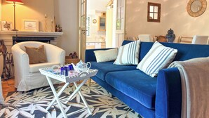 A living room with a blue sofa, white armchair, and a small table with a tray. - Pichilemu - Private Beach - Trouville-sur-Mer (Trouville-sur-Mer)