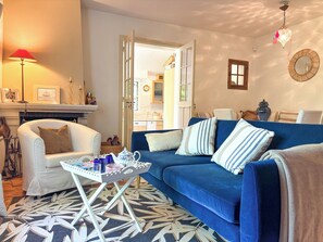 A living room with a blue sofa, white armchair, and a small table with a tray. - Pichilemu - Private Beach - Trouville-sur-Mer (Trouville-sur-Mer)