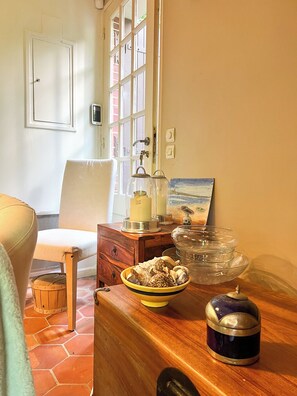 A room with a wooden table, a chair, a window with curtains, and a door. - Pichilemu - Private Beach - Trouville-sur-Mer (Trouville-sur-Mer)