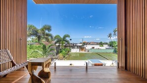 Un interior moderno con piso de madera, una silla tejida y una mesa.