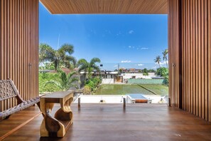 Un interior moderno con piso de madera, una silla tejida y una mesa.