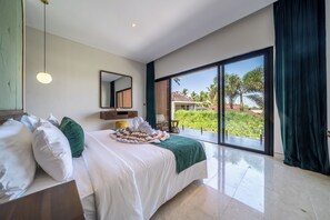 A modern hotel room with a large bed, a mirror, a view of the outdoors, and a balcony. - Sunny Villas Ubud (Gianyar)