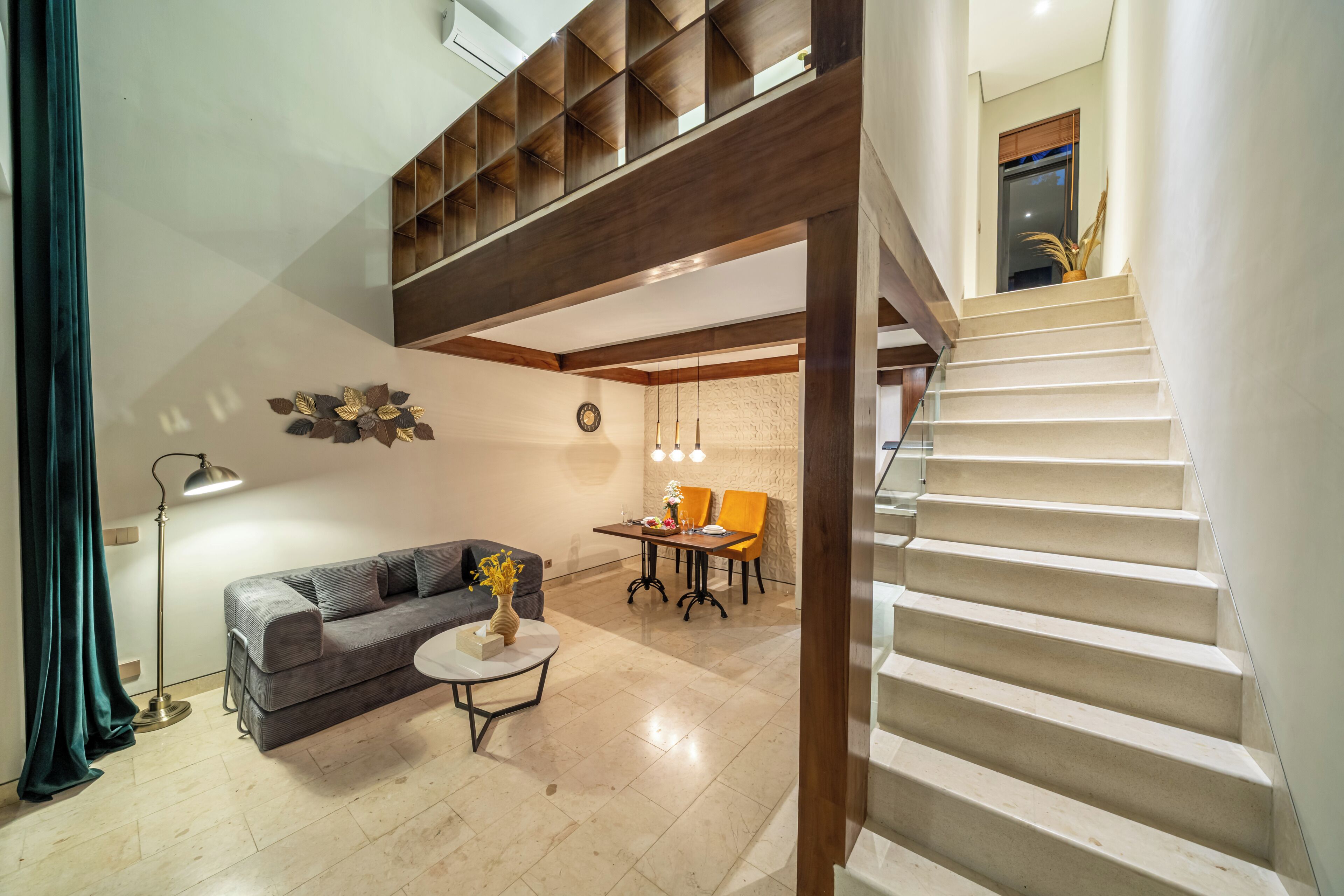 A modern interior with a staircase, a sofa, a dining table, and a coffee table.