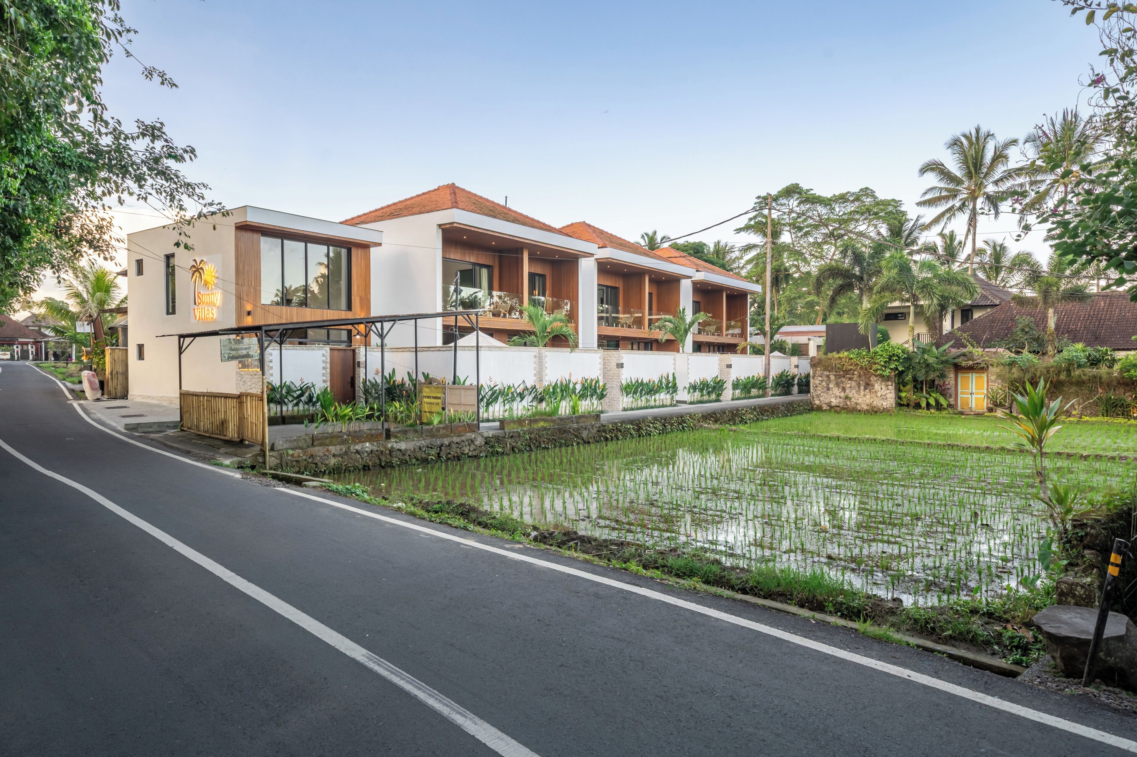 A modern villa with a large balcony, a swimming pool, and a well-maintained garden.