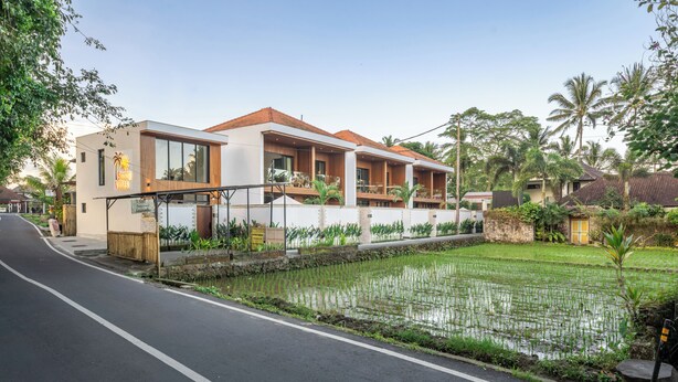 Una villa moderna con un balcón grande, piscina y un jardín bien cuidado.