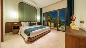 Habitación de hotel con una cama grande, una mesita de noche de madera, un cabecero integrado, un ventanal con vista a palmeras y un aparador de madera con un jarrón de flores.