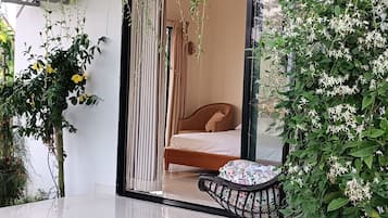 A modern bedroom with a bed, a chair, and a window.