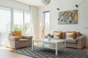 A modern living room with two sofas, a coffee table, and a painting of zebras.