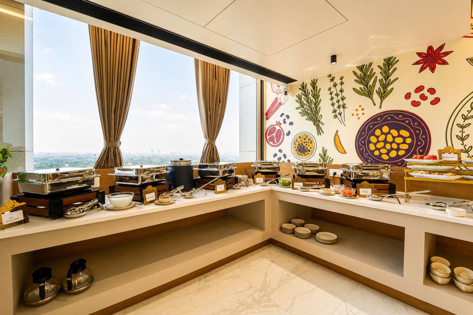 A buffet setup with various food stations, a city view through large windows, and a wall decorated with plant illustrations.