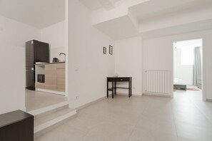 A modern, minimalistic apartment with a kitchen, a small table, and a radiator. - A cozy 60 sqm apartment that sleeps up to 4 people, located on the semi-basement level of a building (accessible via stairs).The neighborhood is well-connected to the city center and major attractions by public transport; the Tolstoj stop on the M4 met (Milan)