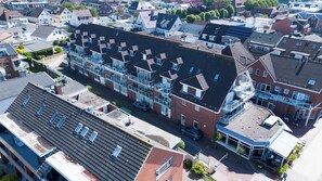 A multi-story residential building with a central courtyard, balconies, and a mix of brick and modern facades. - Vrbo Property (Büsum)