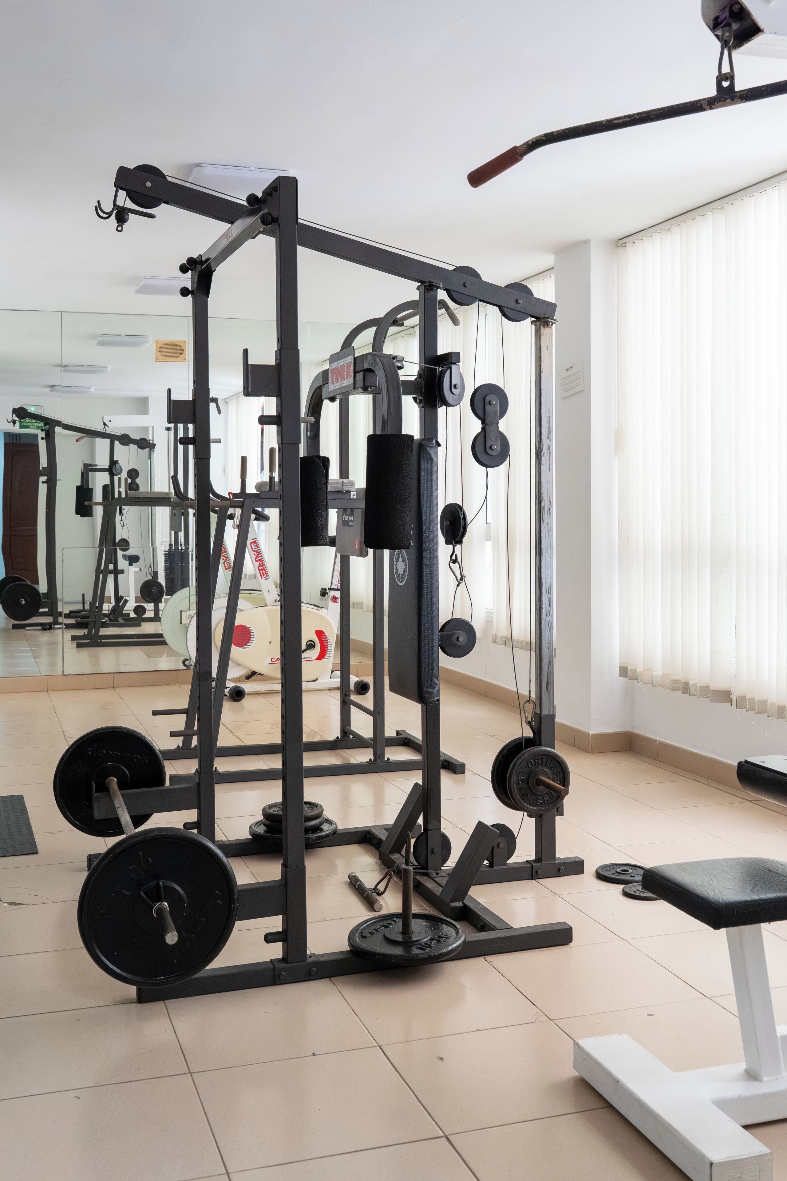 A gym with various exercise equipment, including weight machines and free weights.