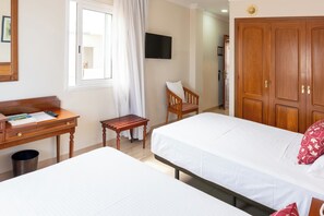 A hotel room with two beds, a desk, a chair, a television, and a wardrobe. - Hotiday Tenerife Norte (Puerto de la Cruz)