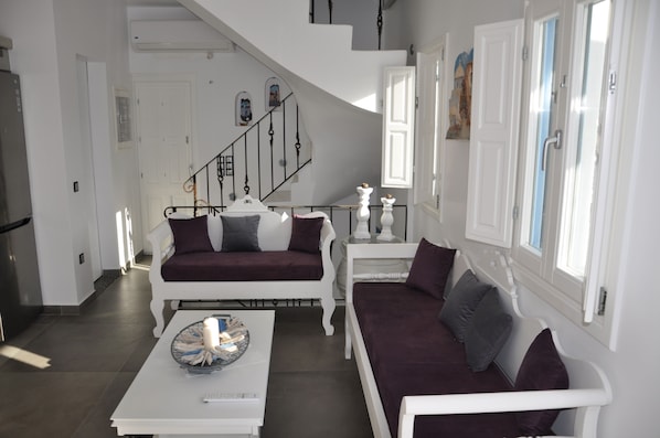 A modern living room with a white staircase, a sofa set, and a coffee table.