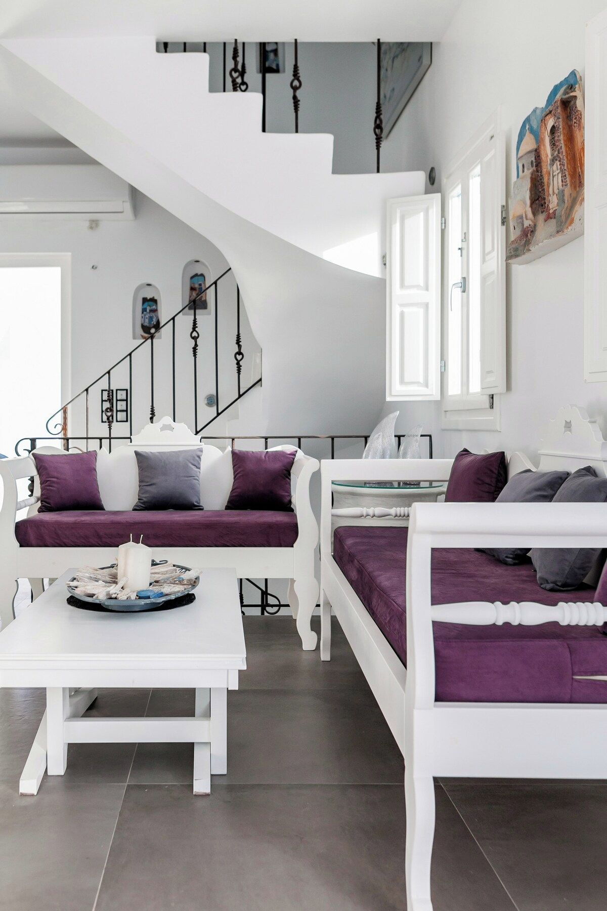 Ein modernes Interieur mit einer weißen Treppe, einer Sofagarnitur und einem Esstisch.