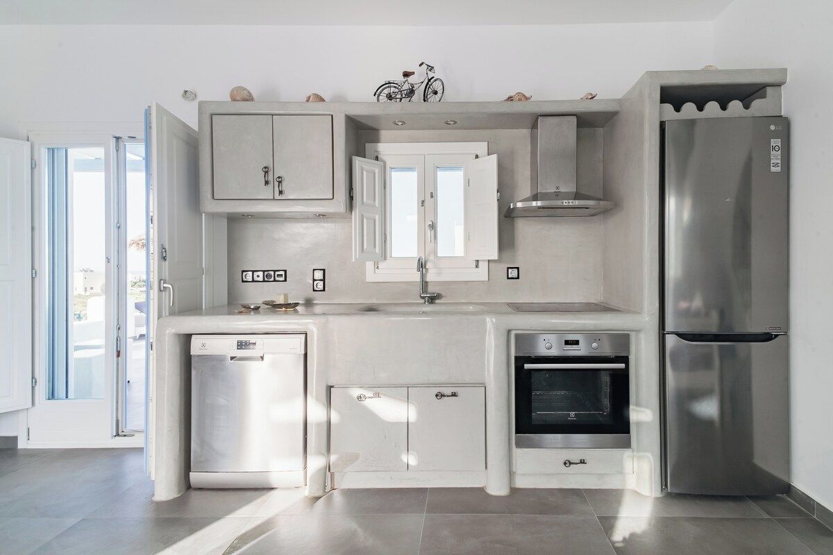 Eine moderne Küche mit Geschirrspüler, Backofen und Kühlschrank.