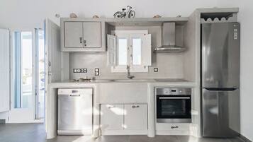 Eine moderne Küche mit Geschirrspüler, Backofen und Kühlschrank.