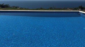 Una piscina blu cristallina con vista sull'oceano.