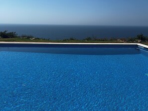 Ein klares, blaues Schwimmbecken mit Blick auf den Ozean.