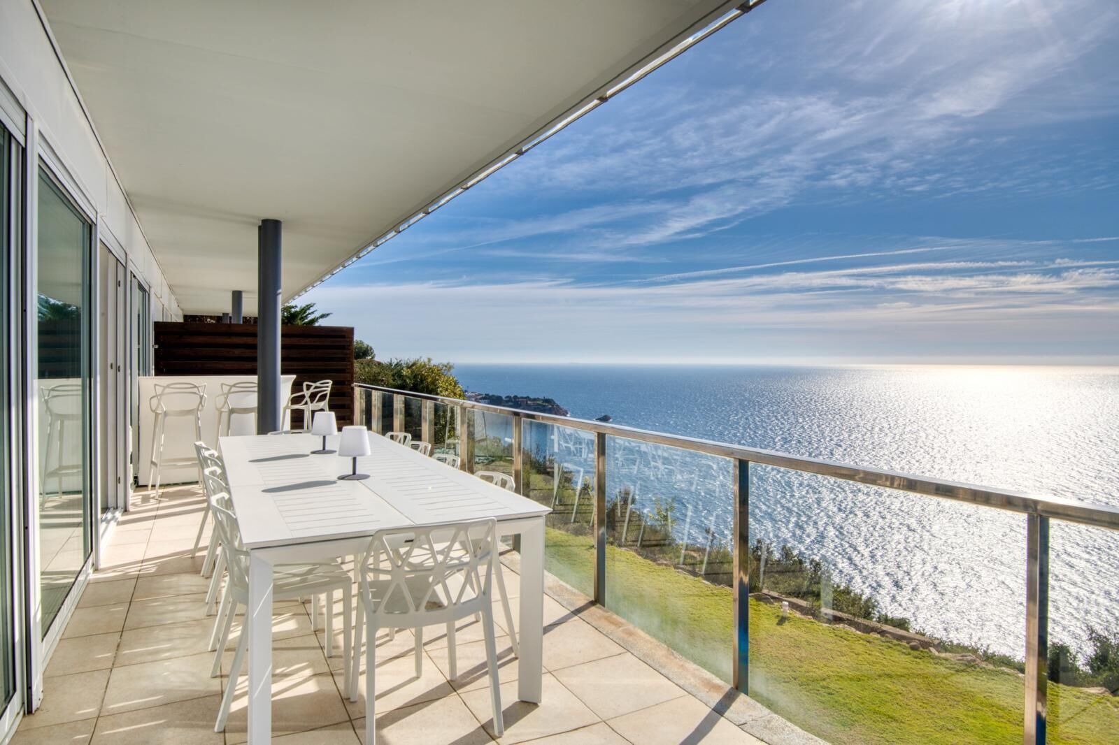 Un balcon avec une table et des chaises, donnant sur une étendue d’eau.