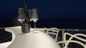 Un tavolo con una bottiglia e bicchieri, illuminato da un cielo notturno con la luna visibile.