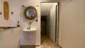 Et badeværelse med toilet, håndvask og spejl.