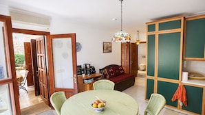 A room with a dining table, chairs, a sofa, a coffee station, and a green cabinet. - Villa Sophia (KAŞ)