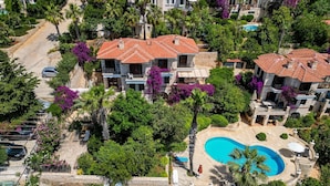 A residential area with multiple houses, a swimming pool, and lush greenery. - Villa Sophia (KAŞ)