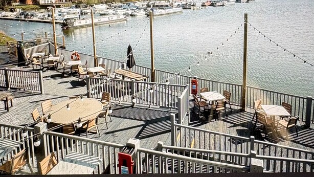 A waterfront restaurant deck with outdoor seating and a view of boats on the water. - Billing Aquadrome 2-bed Caravan, Sleeps 6, Parking (Northampton)