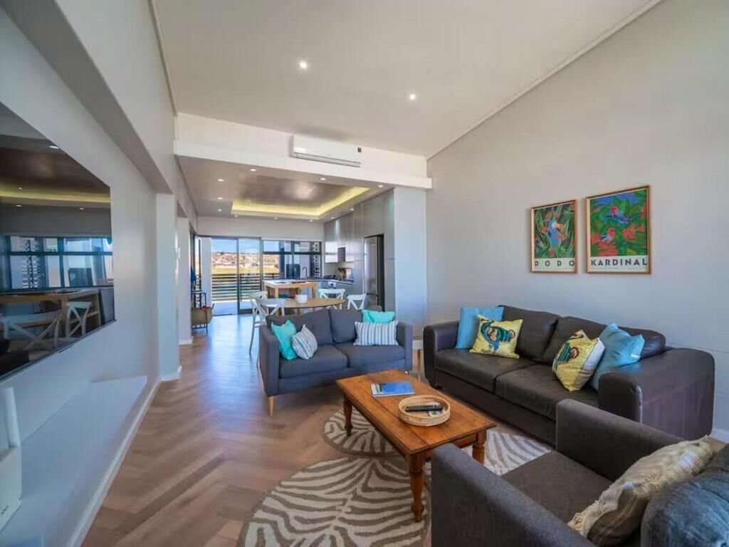 A modern living room with a sofa, coffee table, and artwork on the wall.