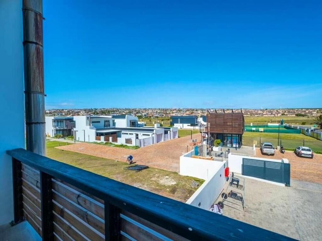 Un edificio moderno con tetto piatto, un'area di parcheggio e una vista aperta sul paesaggio circostante.