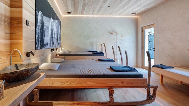 A modern spa room with a wooden bench, a stone basin, and a large painting on the wall. - Oberwidner Aura – Luxury Suite in Sarntal (Sarntal)