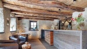 Eine rustikale Küche mit sichtbaren Holzbalken, einer Holztresen und einem Fenster mit Blick.
