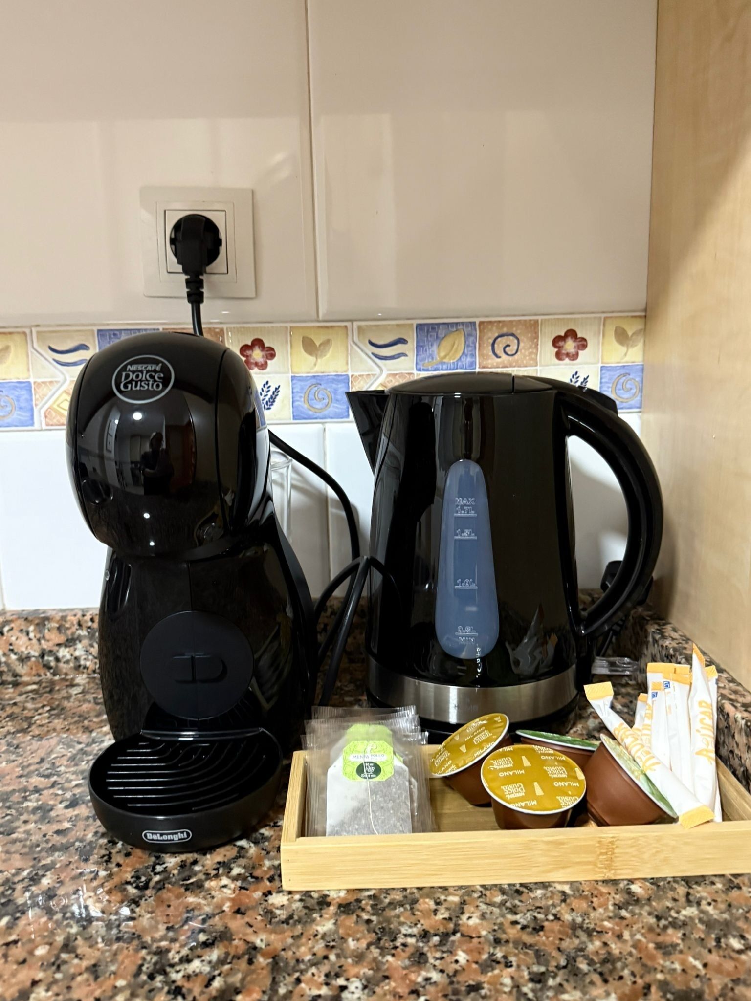 Una cuina amb una cafetera, un brollador i una safata amb menjar.