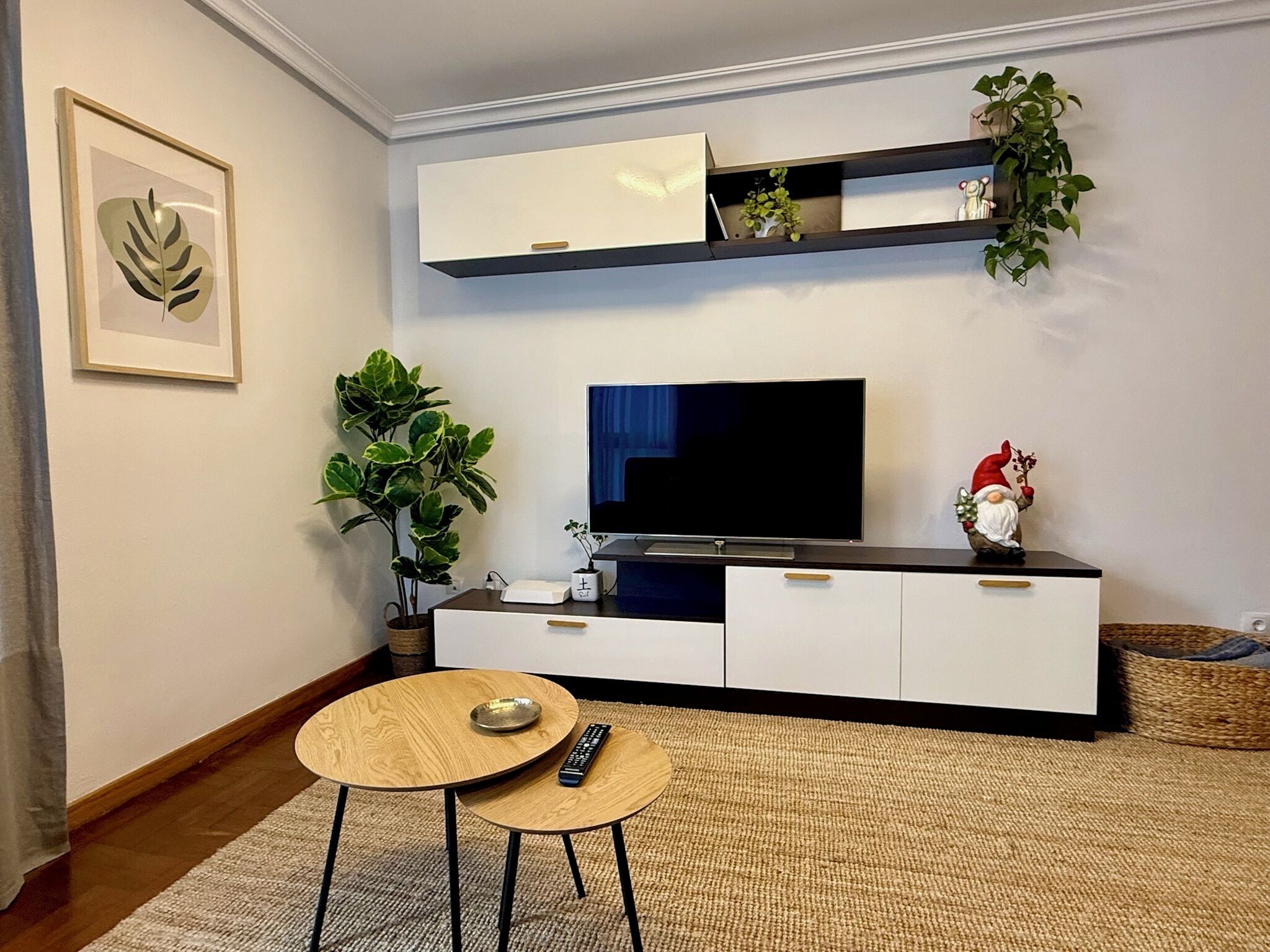 Una sala de estar con televisor de pantalla plana, una mesita de centro y un sofá.