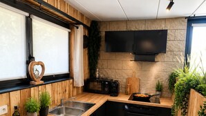 Una cocina moderna con armarios de madera, estufa negra y microondas integrado.