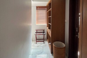 A hallway with a wooden wardrobe, a small table, and a trash bin. - 3 Bedroom Private Pool Villa in Bali (Kerobokan Kelod, Kec. Kuta Utara, Kabupaten Badung)