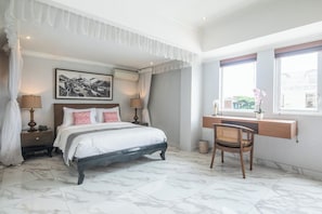 A bedroom with a bed, bedside lamps, a picture on the wall, a window with a view, and a desk with a chair. - 3 Bedroom Private Pool Villa in Bali (Kerobokan Kelod, Kec. Kuta Utara, Kabupaten Badung)