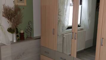 Une pièce avec une armoire en bois, un radiateur et un tableau encadré accroché au mur.