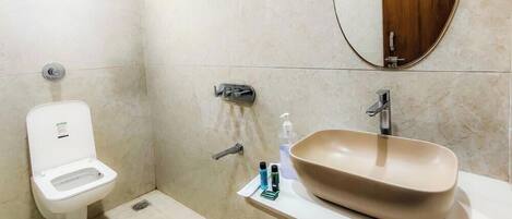 Een badkamer met toilet, wastafel en spiegel.
