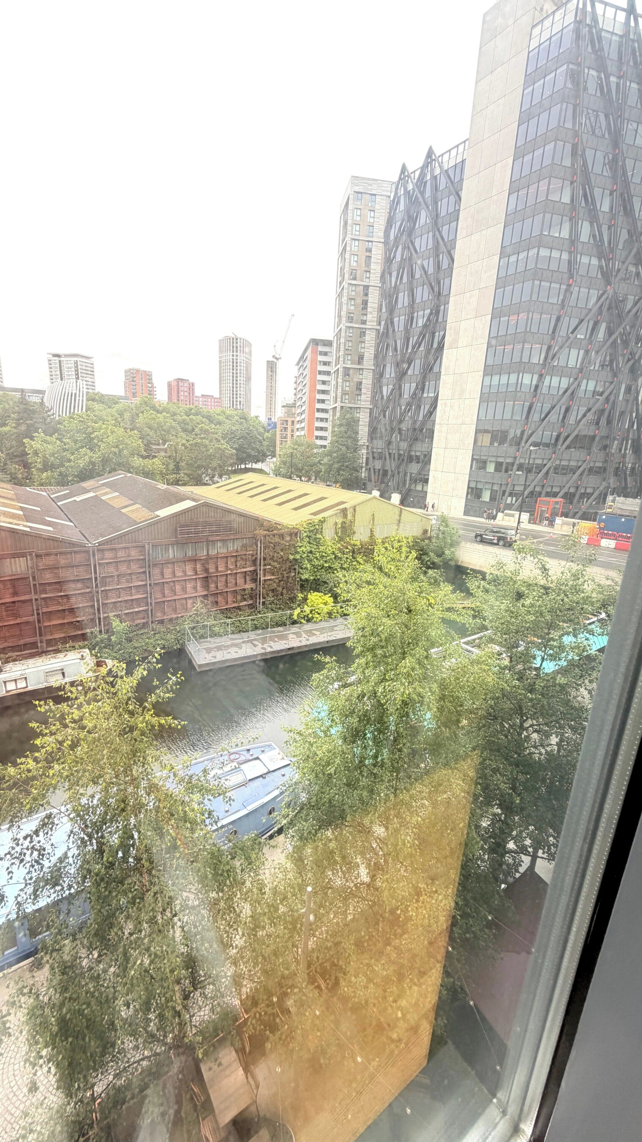 A view of a cityscape with modern buildings, a river, and a bridge.