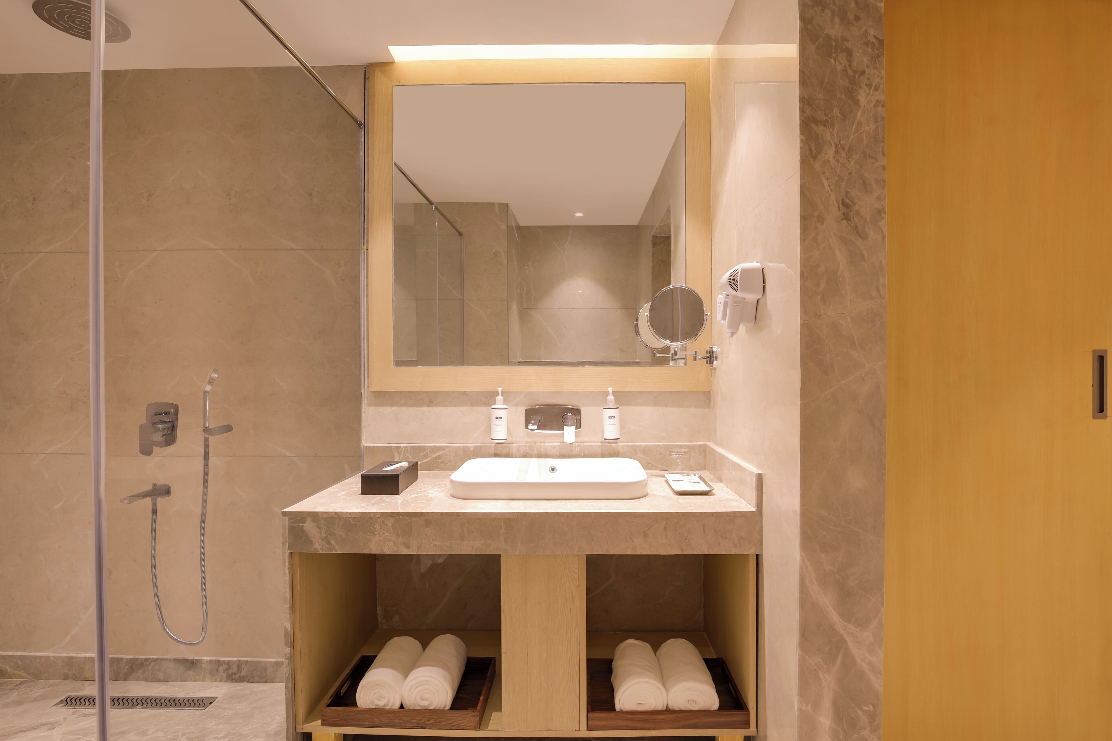 A modern bathroom with a large mirror, a sink, and a shower.