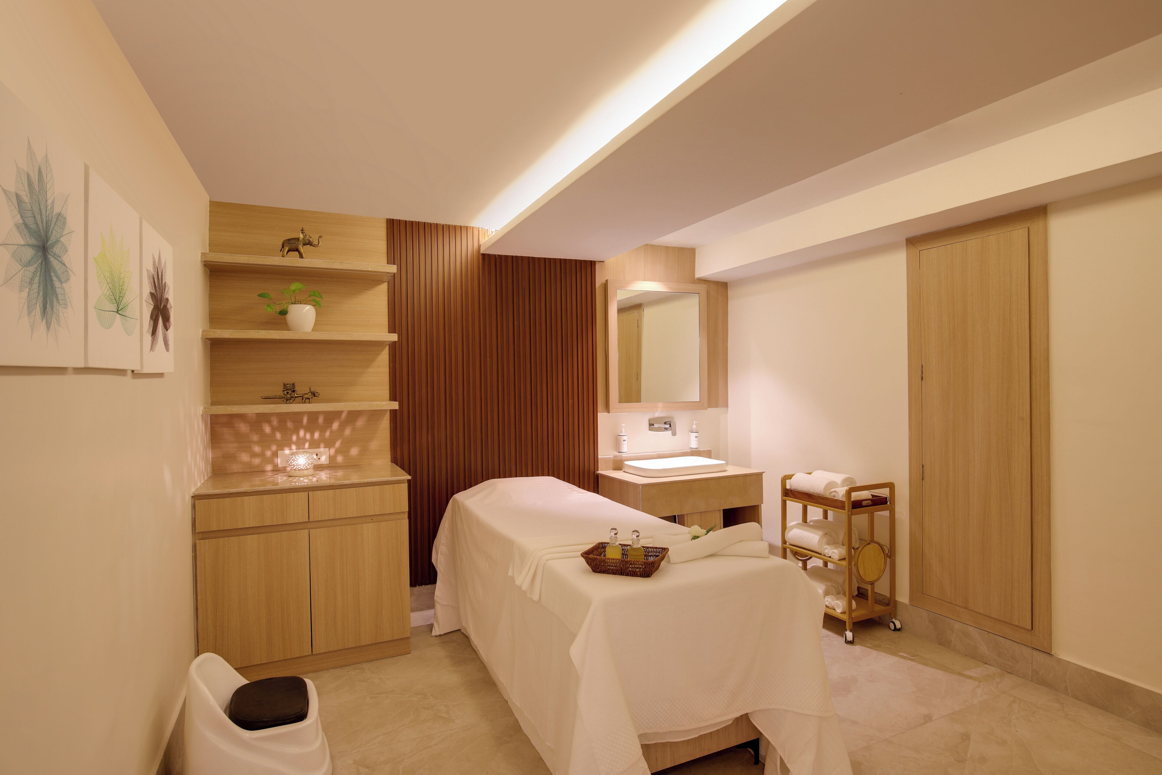 A modern bathroom with a wooden vanity, a sink, a mirror, a towel rack, and a shelf with decorative items.