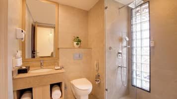A bathroom with a toilet, sink, and shower.