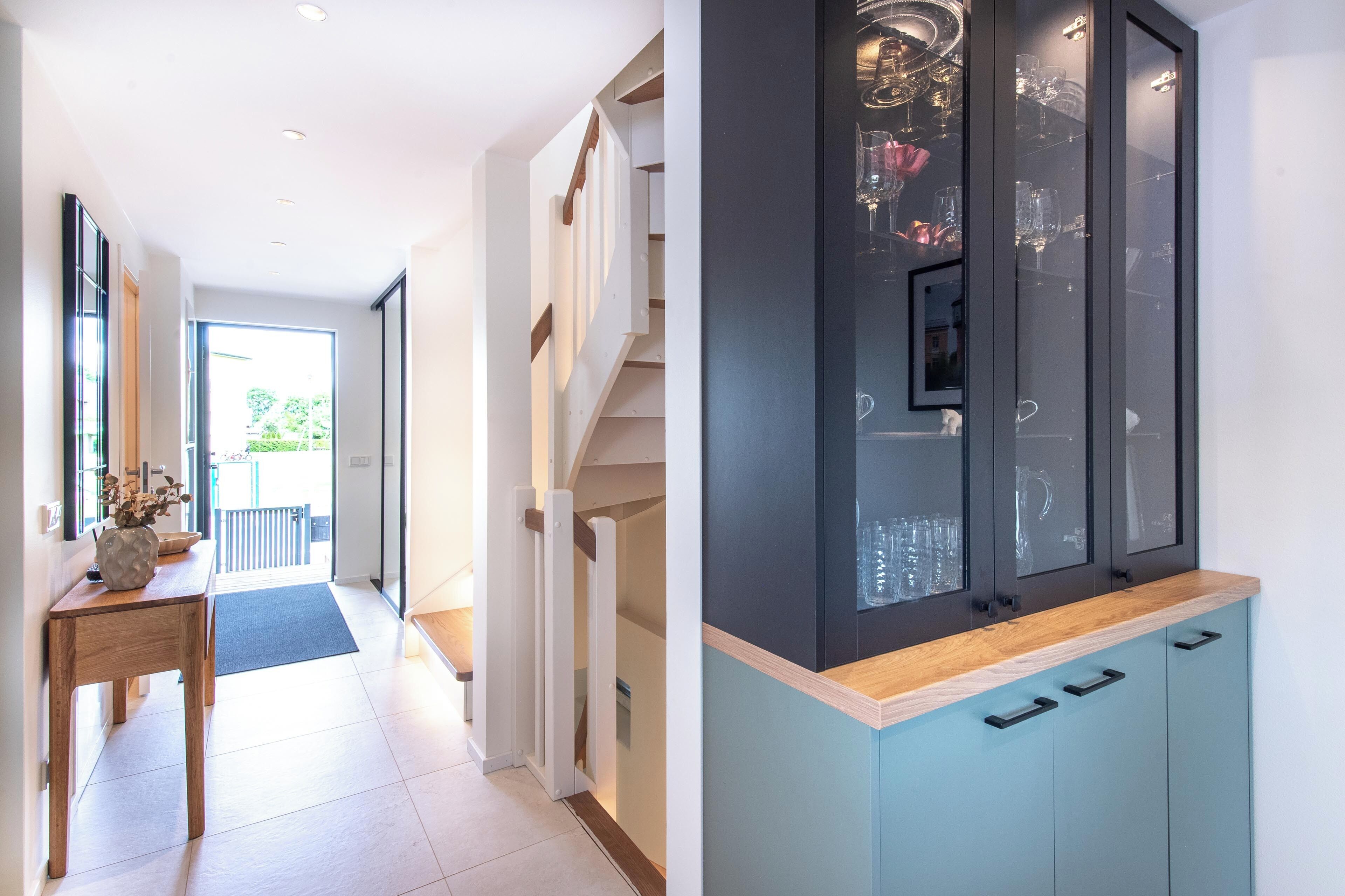 A modern kitchen with a wooden countertop, cabinets, and a built-in wine rack.