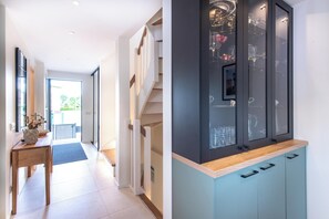 A modern kitchen with a wooden countertop, cabinets, and a built-in wine rack.