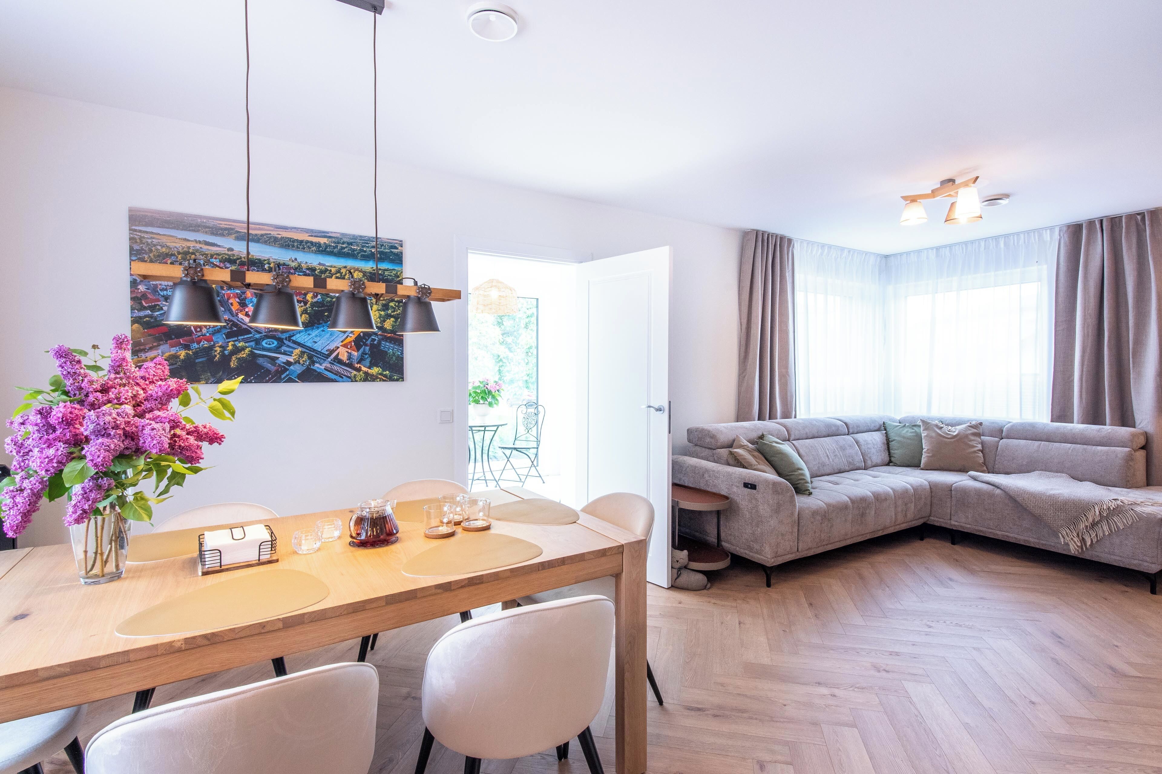 Una sala de estar moderna con comedor, un sofá y un cuadro en la pared.