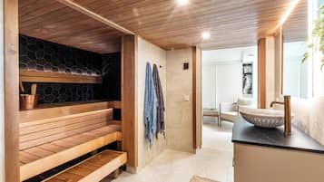 Un baño moderno con un banco de madera, una pared de piedra y un lavamanos grande con un cuenco decorativo.